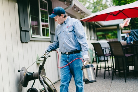 Pest Tech Treating around a home.